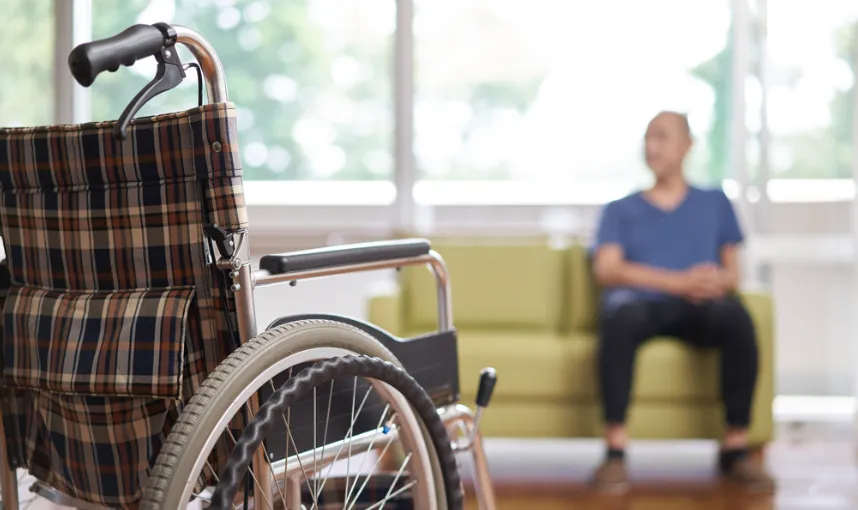 Person working part-time while reviewing long-term disability benefits and insurance claim documents at home.