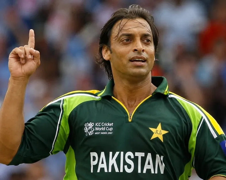 Shoaib Akhtar celebrating on the cricket field in Pakistan team jersey during an international match.